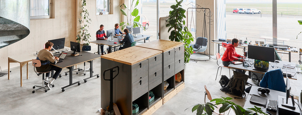 Modern coworking space with professionals at shared desks, natural light, and collaborative layout—showcasing Switzerland’s innovation hubs for startups and R&D teams.